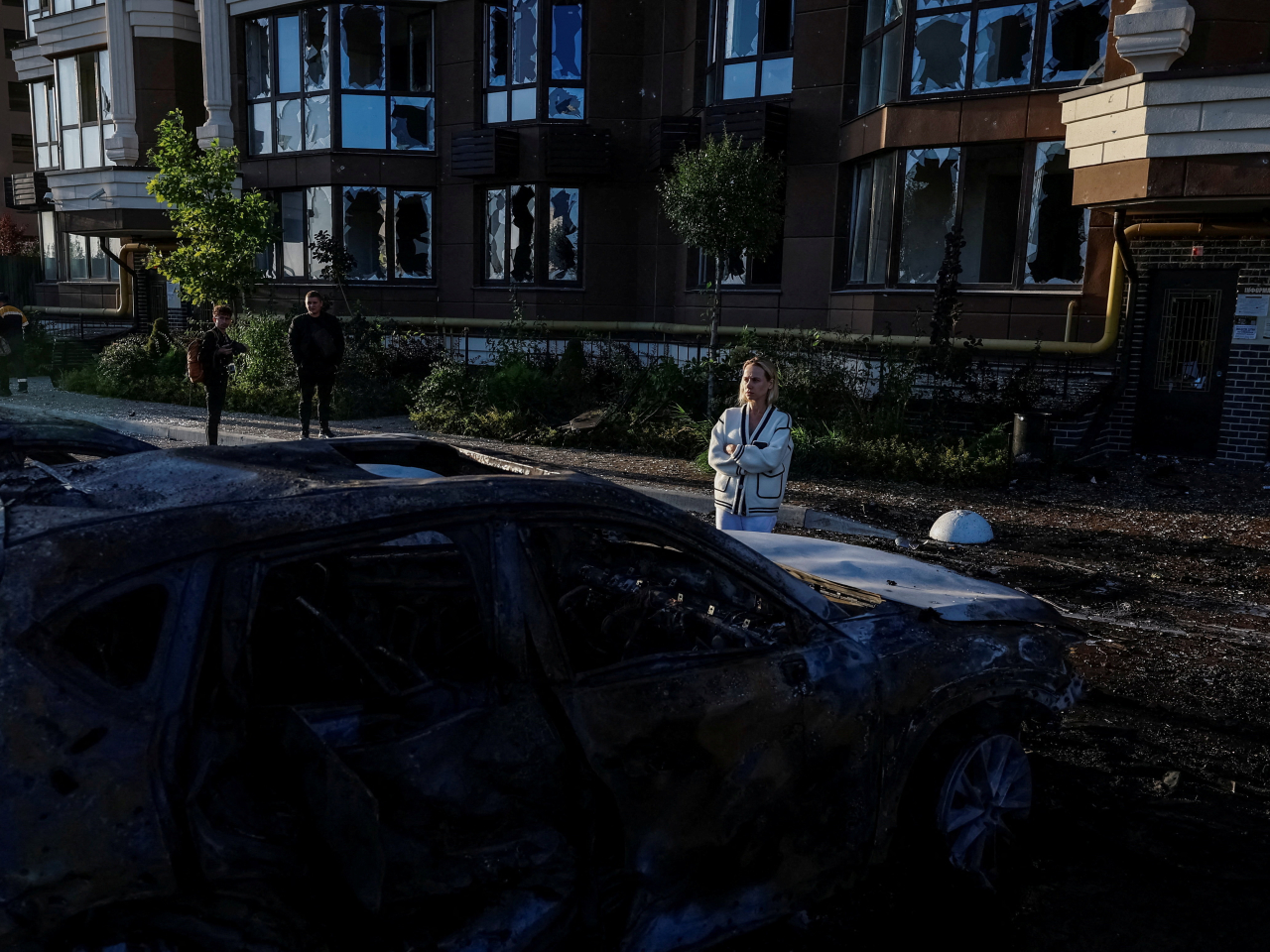 A resident looks at her damaged car at the site of a residential building hit during a Russian drone and missile strike in Kyiv. Photo: Reuters
