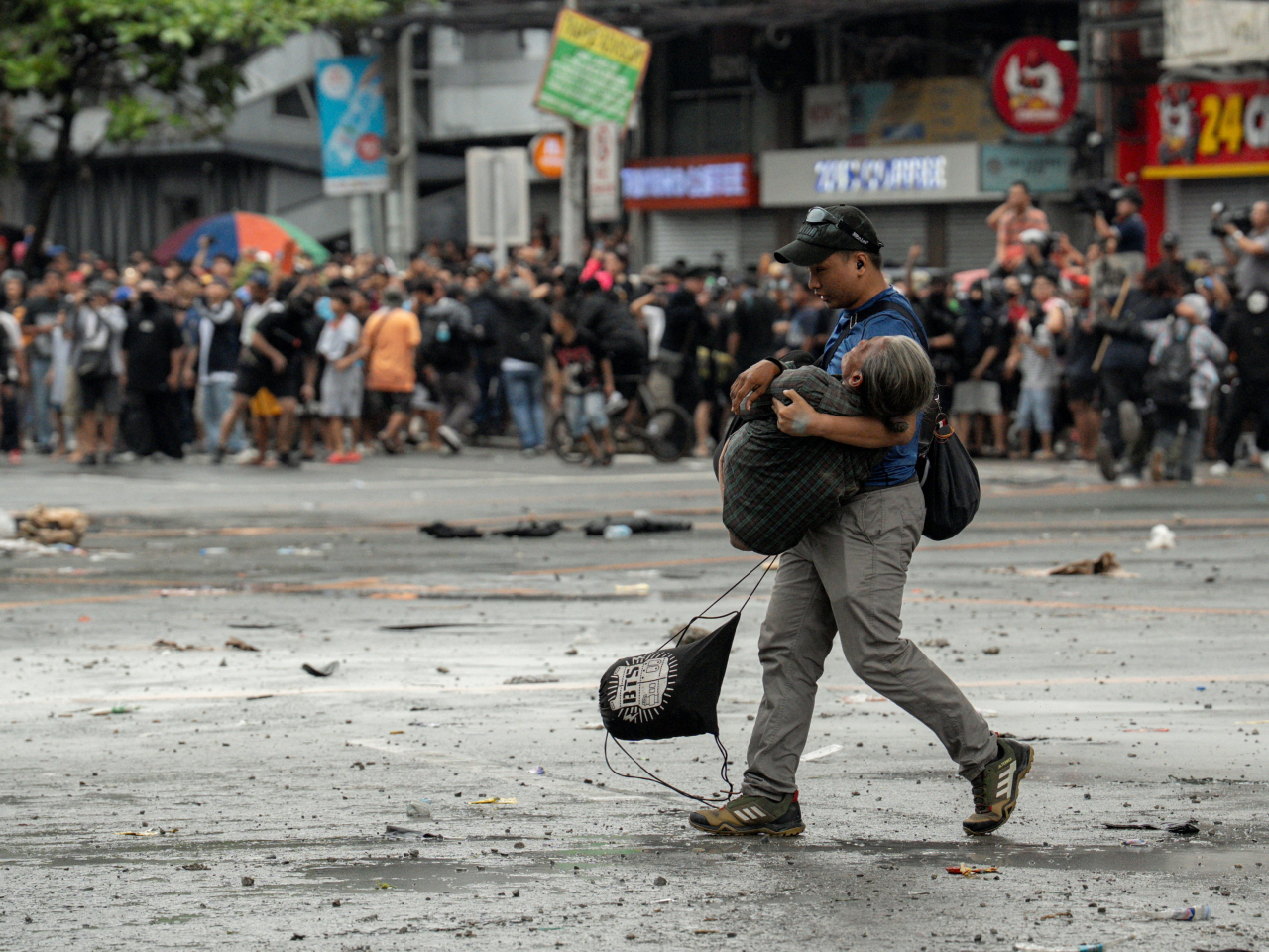 An elderly woman is carried to a medical centre amid the Manila protests on Sunday. Photo: Reuters