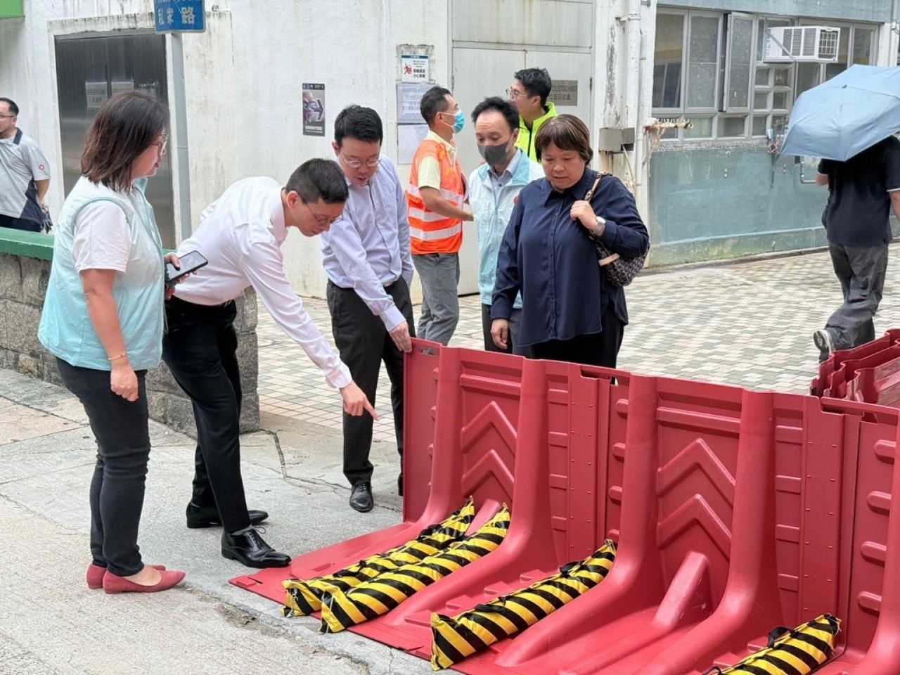 陳欽勉重點勘查水浸警報系統運作情況，鄰近山坡的樓宇加設擋水板確保所有防禦措施落實到位。（房協社交網站圖片）