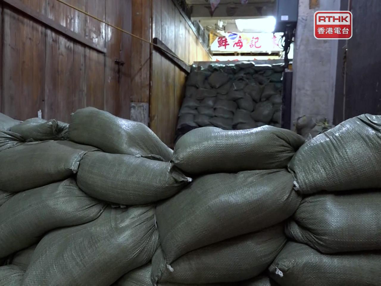 消防人員到場巡視，當局在接近岸邊的通道堆放大量沙包。（麥偉康攝）