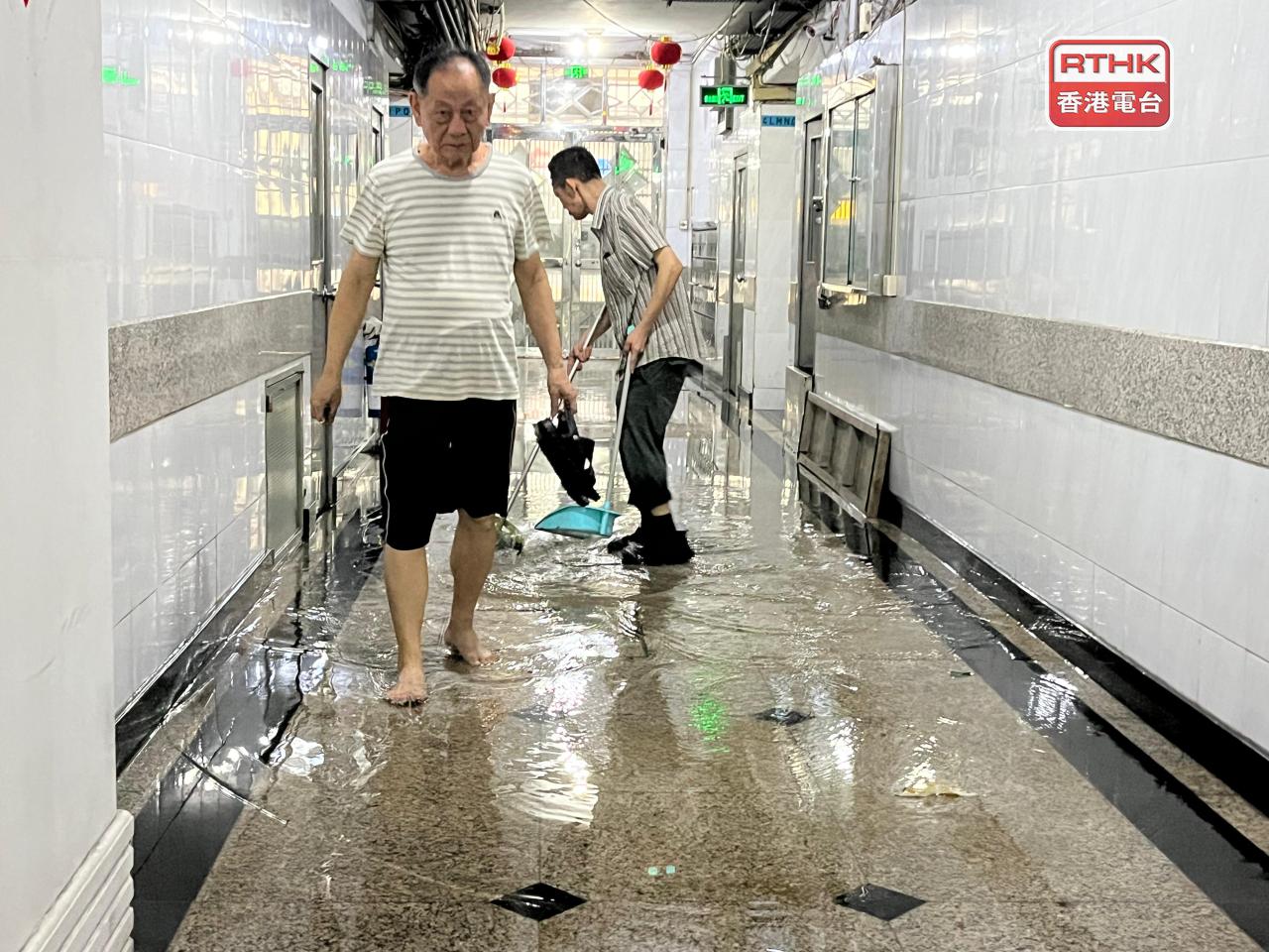 有大廈管理處清理積水，以便在短時間內重開電梯。（鄭月明攝）