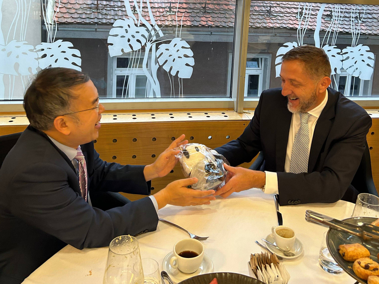 許正宇與斯洛文尼亞副總理兼財政部長Klemen Boštjančič 共晉早餐，向他送上熊貓紀念品。（政府新聞處）