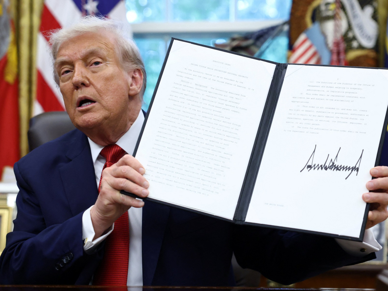 Donald Trump shows a signed executive order on a deal that would divest TikTok's US operations from its Chinese owner ByteDance. Photo: Reuters
