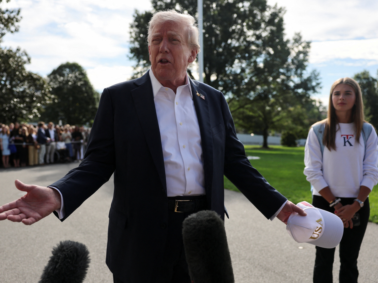 Kai Trump sports one of the pullovers she's promoting as her grandfather speaks at the White House. Photo: Reuters