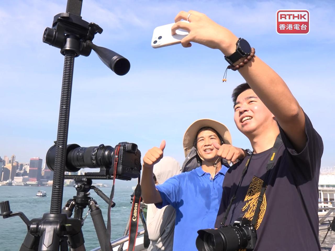 The PLA vessels make for a great selfie opportunity for two people at Tsim Sha Tsui. Photo: RTHK