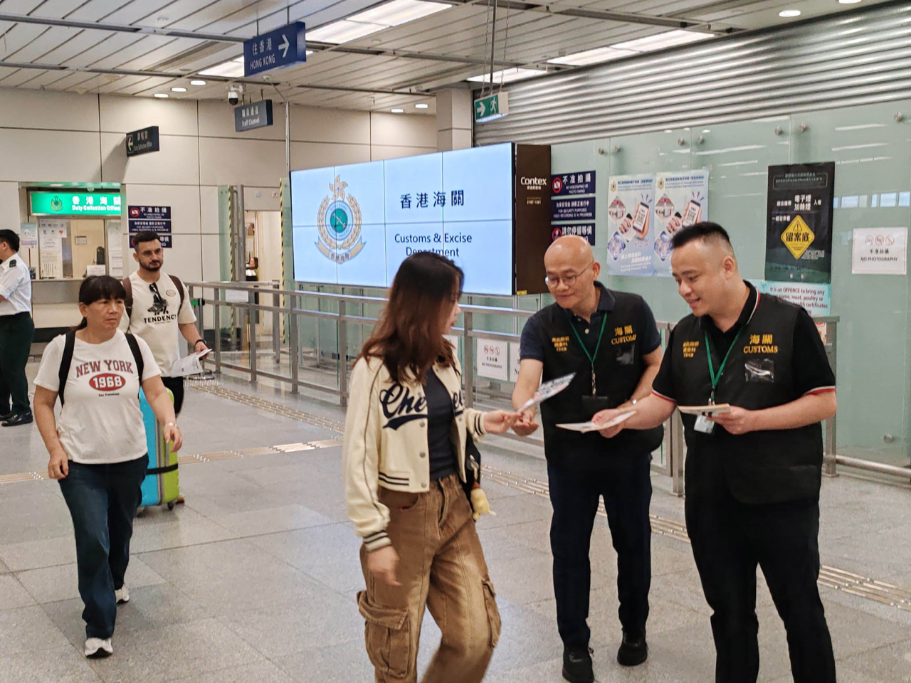 海關人員在深圳灣口岸派發宣傳單張。（政府新聞處）