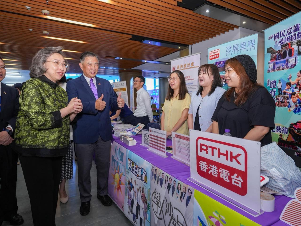 楊何蓓茵（左二）參觀香港電台的展位。（政府新聞處）