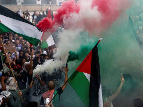 Demonstrators release smoke in the colours of the Palestinian flag at a protest in Barcelona. Photo: Reuters