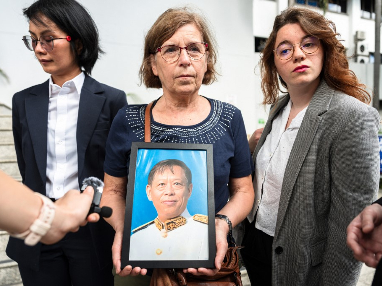 Anne-Marie Lim holds a portrait of her late husband outside court in Bangkok. File photo: AFP
