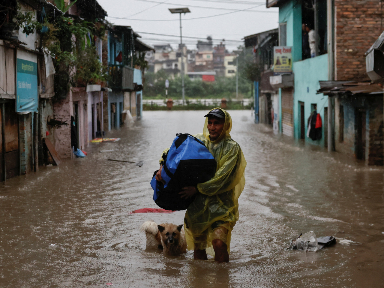 A man wades through a flooded street along the bank of the overflowing Bagmati River following heavy rains in Kathmandu. Photo: Reuters