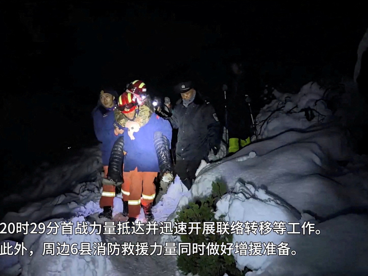 A firefighter piggybacks a hiker left stranded by a blizzard in Tingri. Photo: Reuters