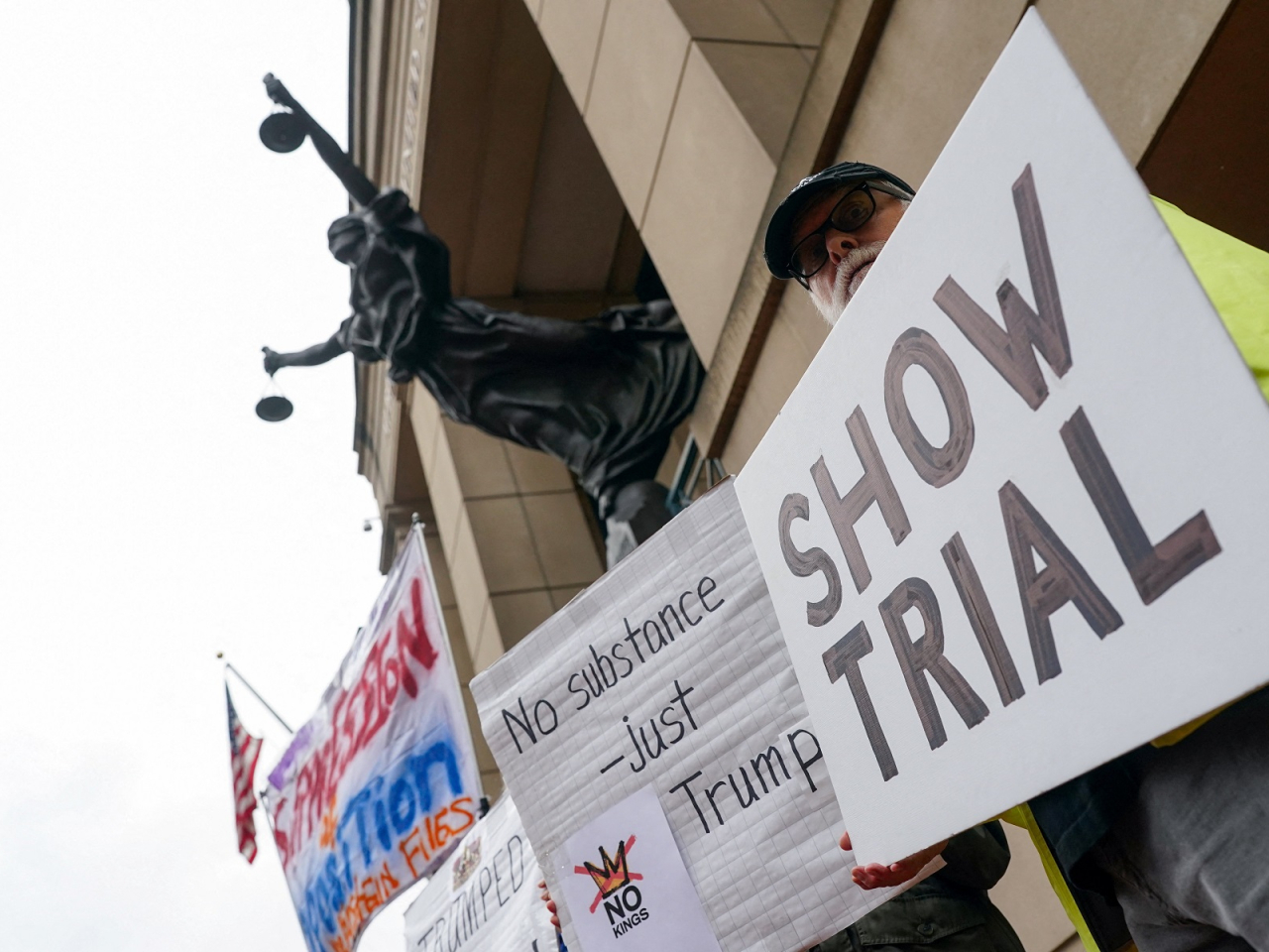 Demonstrators held placards outside the US District Court in Alexandria, Virginia before James Comey arrived to enter a not-guilty plea. Photo: Reuters