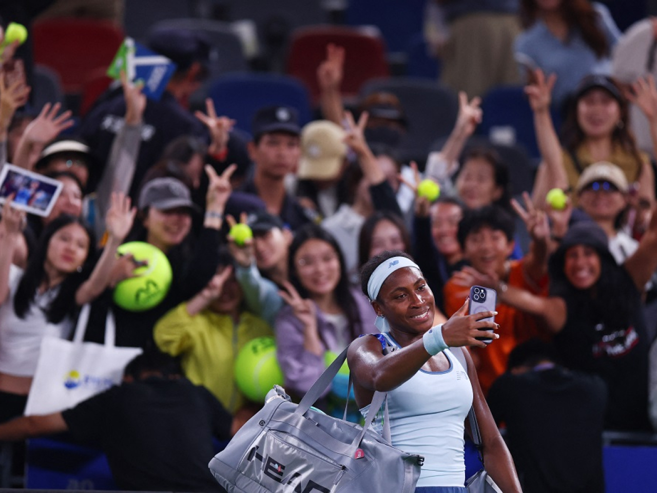 Coco Gauff of the US takes selfies with the spectators after winning her semi final match against Italy's Jasmine Paolini. Photo: Reuters