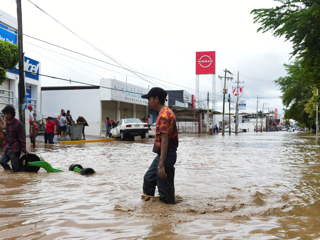 People wade through a flooded street after torrential rains that caused an overflow of rivers in Veracruz. Photo: Reuters