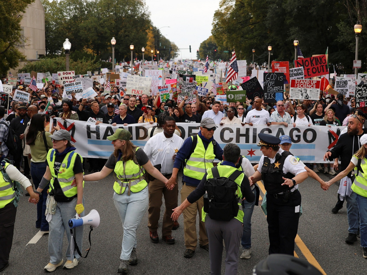 Protesters in Chicago held up a large banner demanding Trump keep his hands off their city. Photo: Reuters