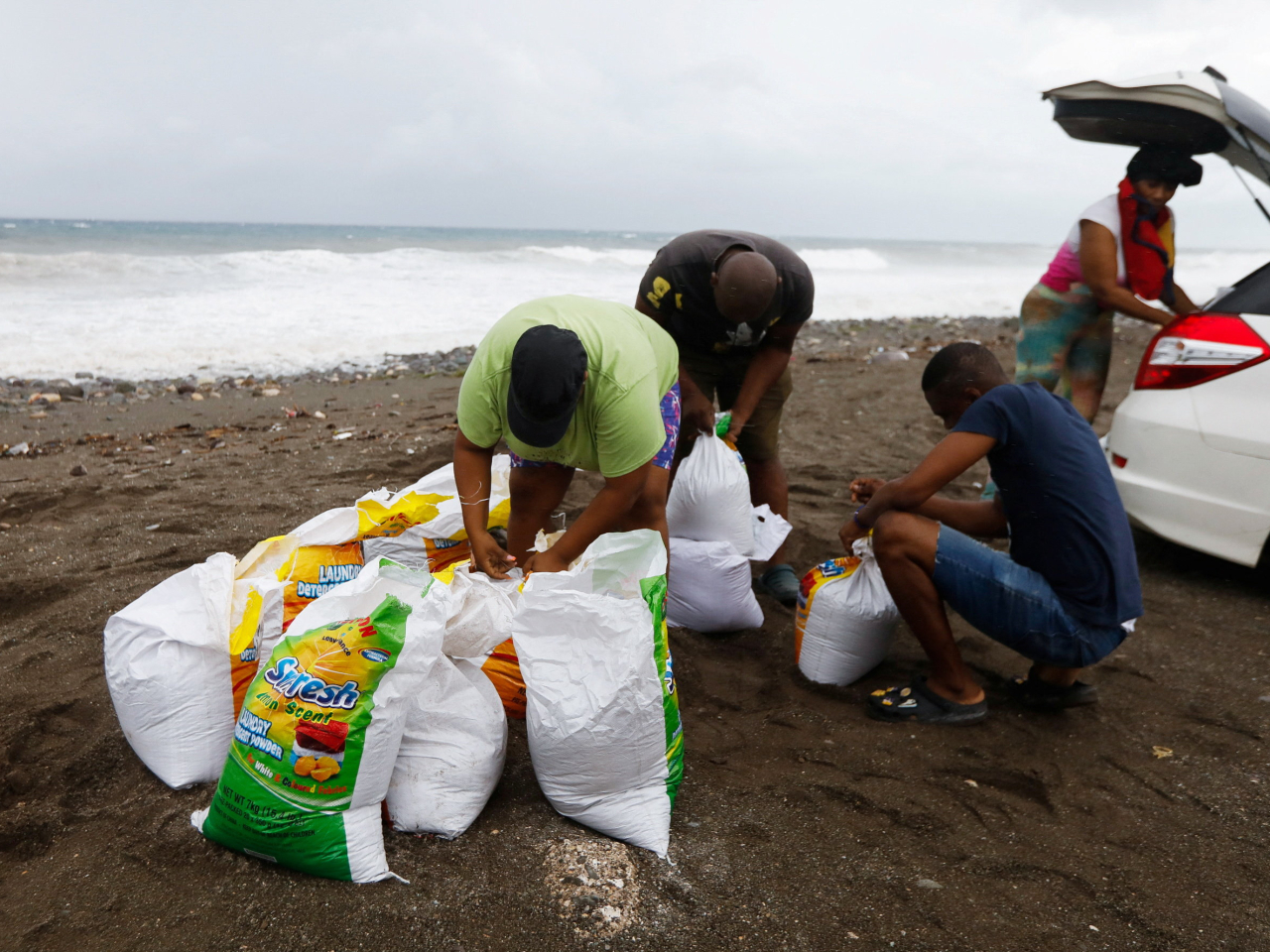 風暴來臨前夕，牙買加居民準備沙包防範洪水。（路透社）