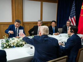 特朗普在會談期間伸出左手，向習近平展示一張白色卡紙，習近平觀看後露出笑容。（白宮圖片）