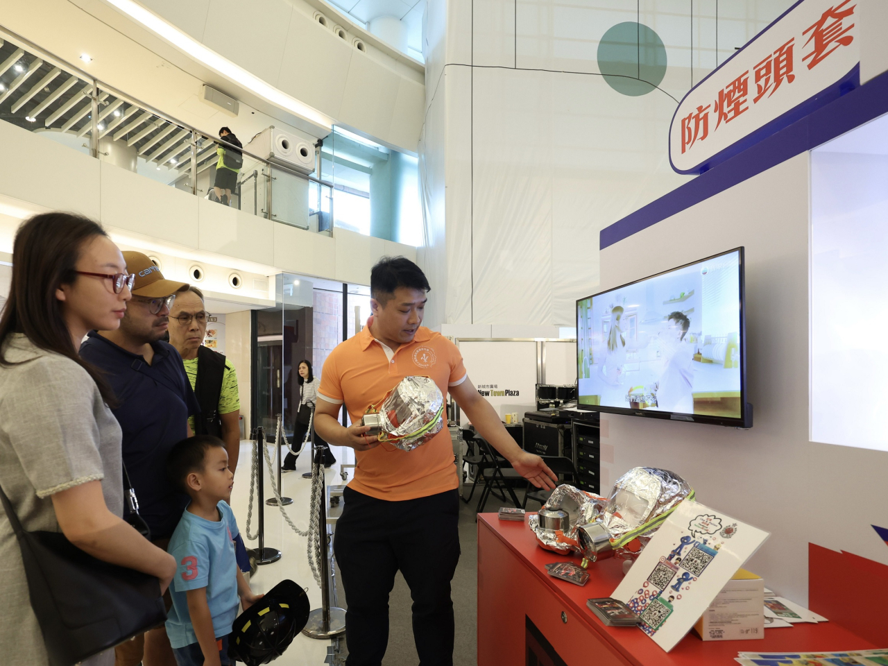 工作人員講解使用防煙頭套過濾濃煙及有害氣體，爭取黃金待救時間。（政府新聞處）