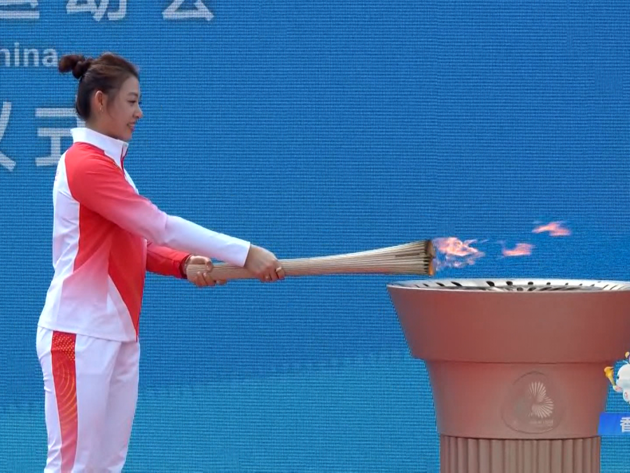 佘繕妡於啟德體育園以火炬燃點火種盆。