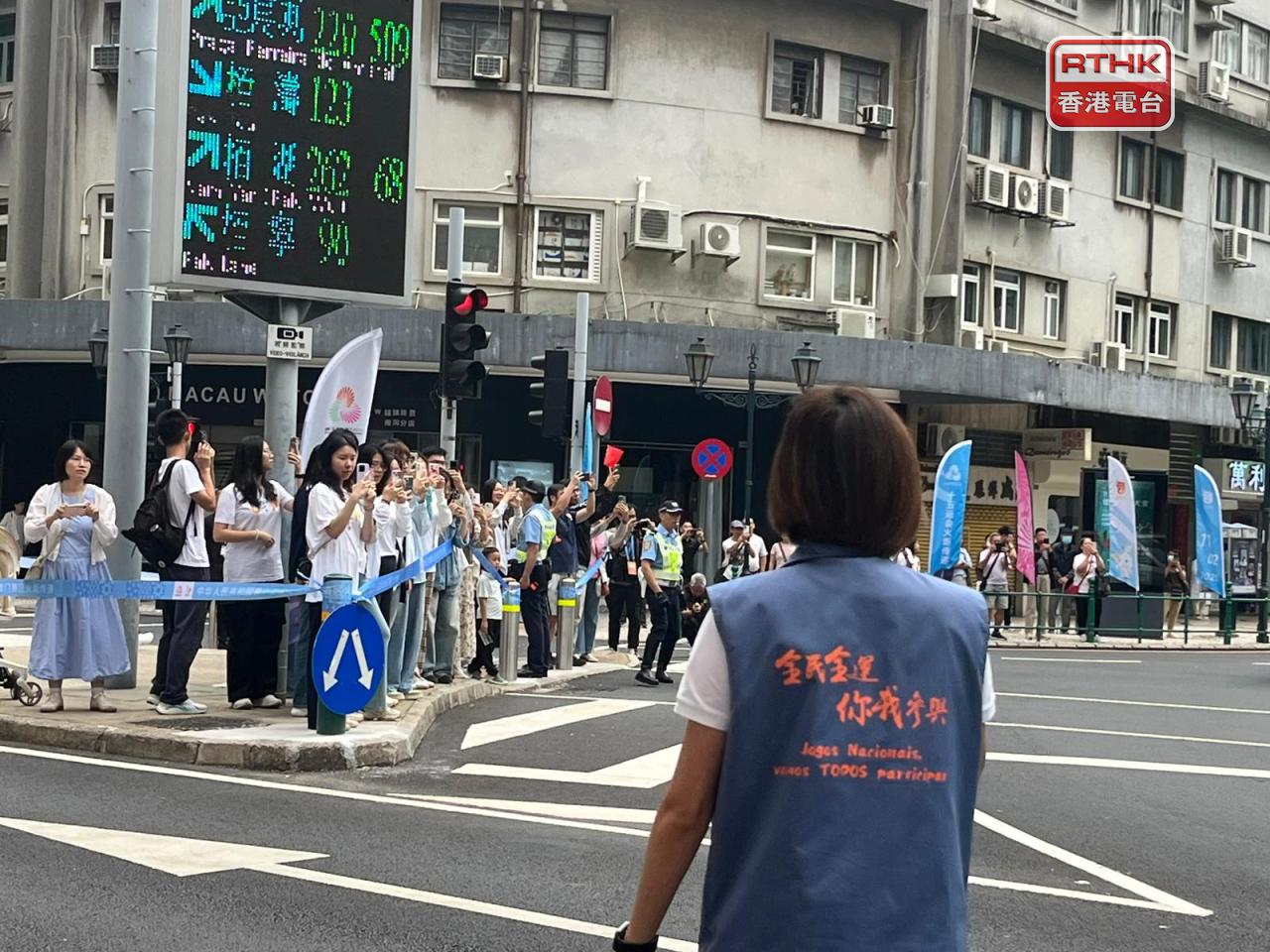 澳門在傳遞火炬沿途採取臨時分段封路措施，不少路過市民駐足觀看和為火炬手打氣。(鄭月明攝)