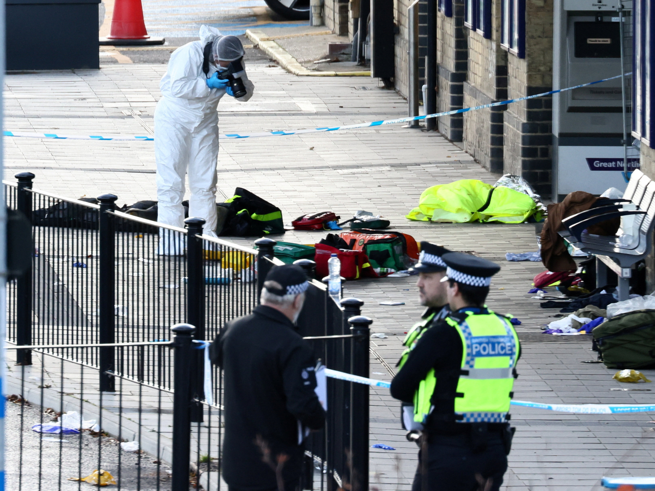 A forensic officer takes pictures in the cordoned-off area at Huntingdon Station, where the suspect was arrested. Photo: Reuters
