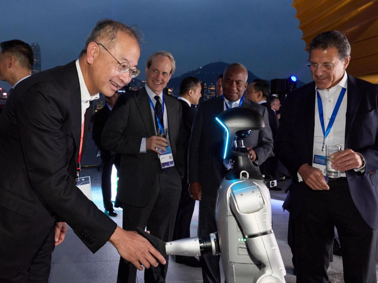歡迎晚宴展示了多款機械人，金管局總裁余偉文（左）與機械人握手。（金管局圖片）