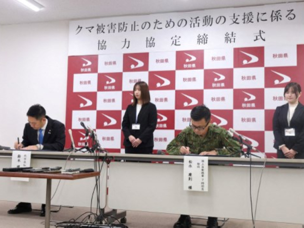 日本秋田縣知事鈴木健太(左)和陸上自衛隊第9師團師團長松永康簽署支援行動相關協定。(法新社)