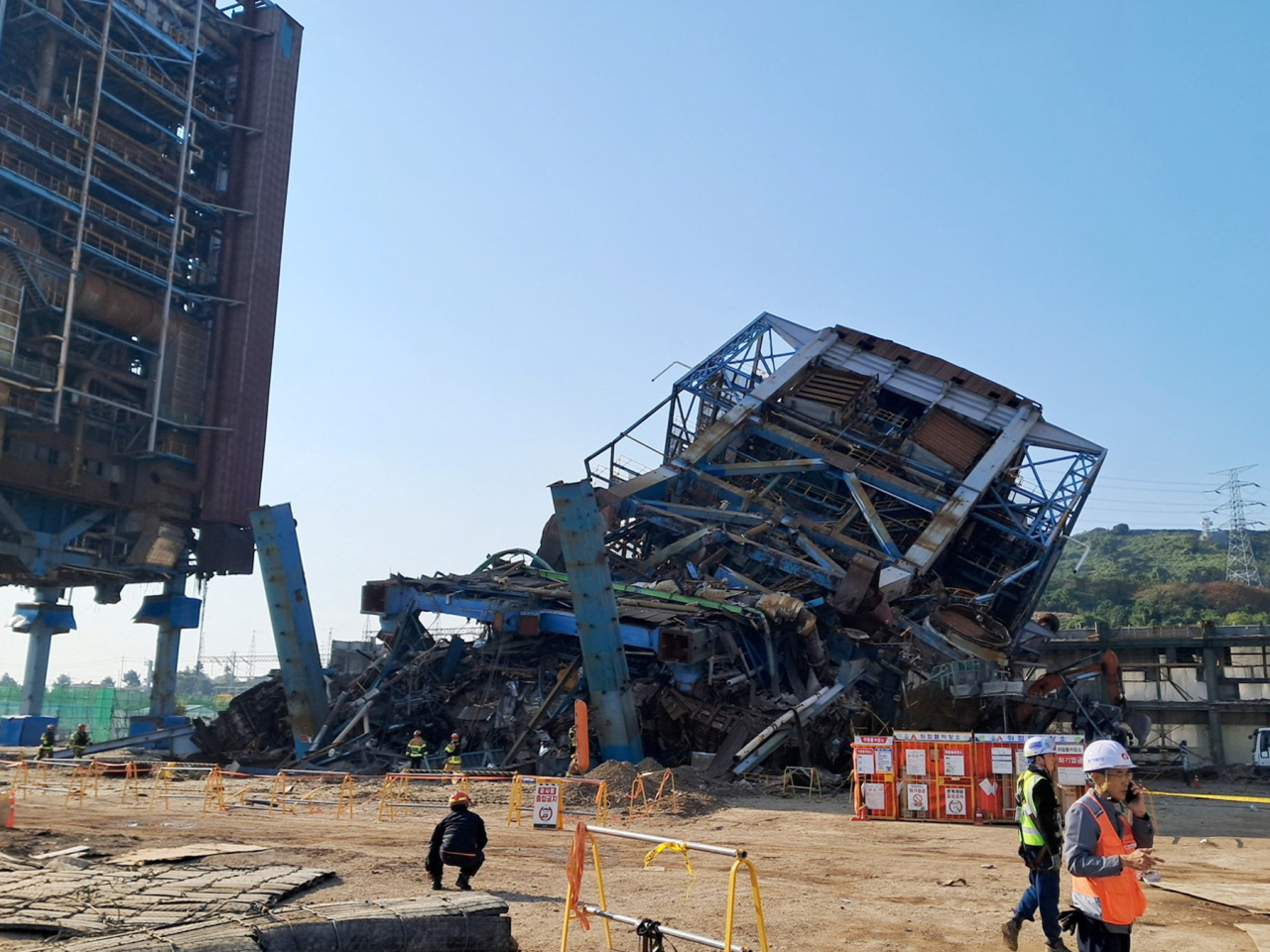 Rescuers walk near a large structure which collapsed and where multiple people are believed to be trapped in Ulsan, South Korea. Photo: Reuters