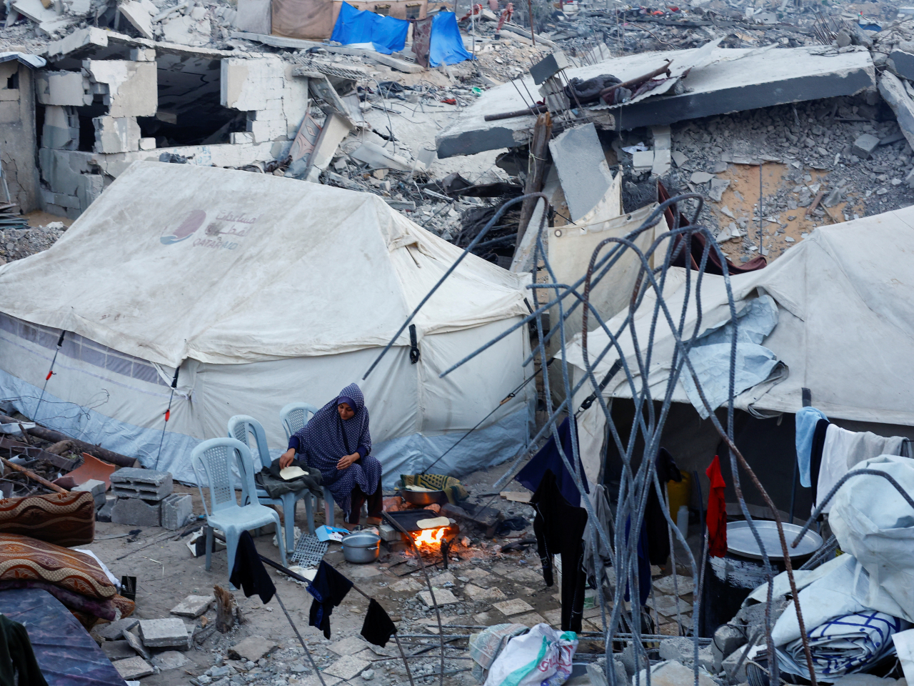 A Palestinian woman prepares food amid the ruins in Jabalia in northern Gaza Strip. Photo: Reuters