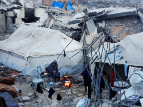 A Palestinian woman prepares food amid the ruins in Jabalia in northern Gaza Strip. Photo: Reuters
