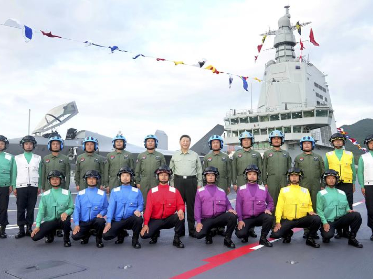 習近平同艦載機飛行員、航空保障人員合影留念。（新華社）