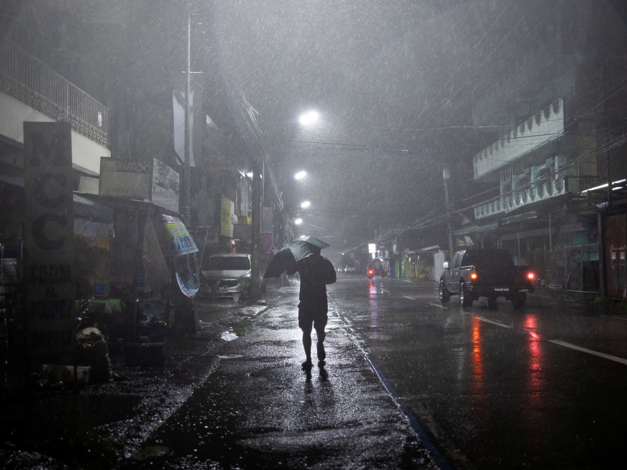 A man walks in the rain in Cauayan, Isabela in the Philippines. Photo: Reuters