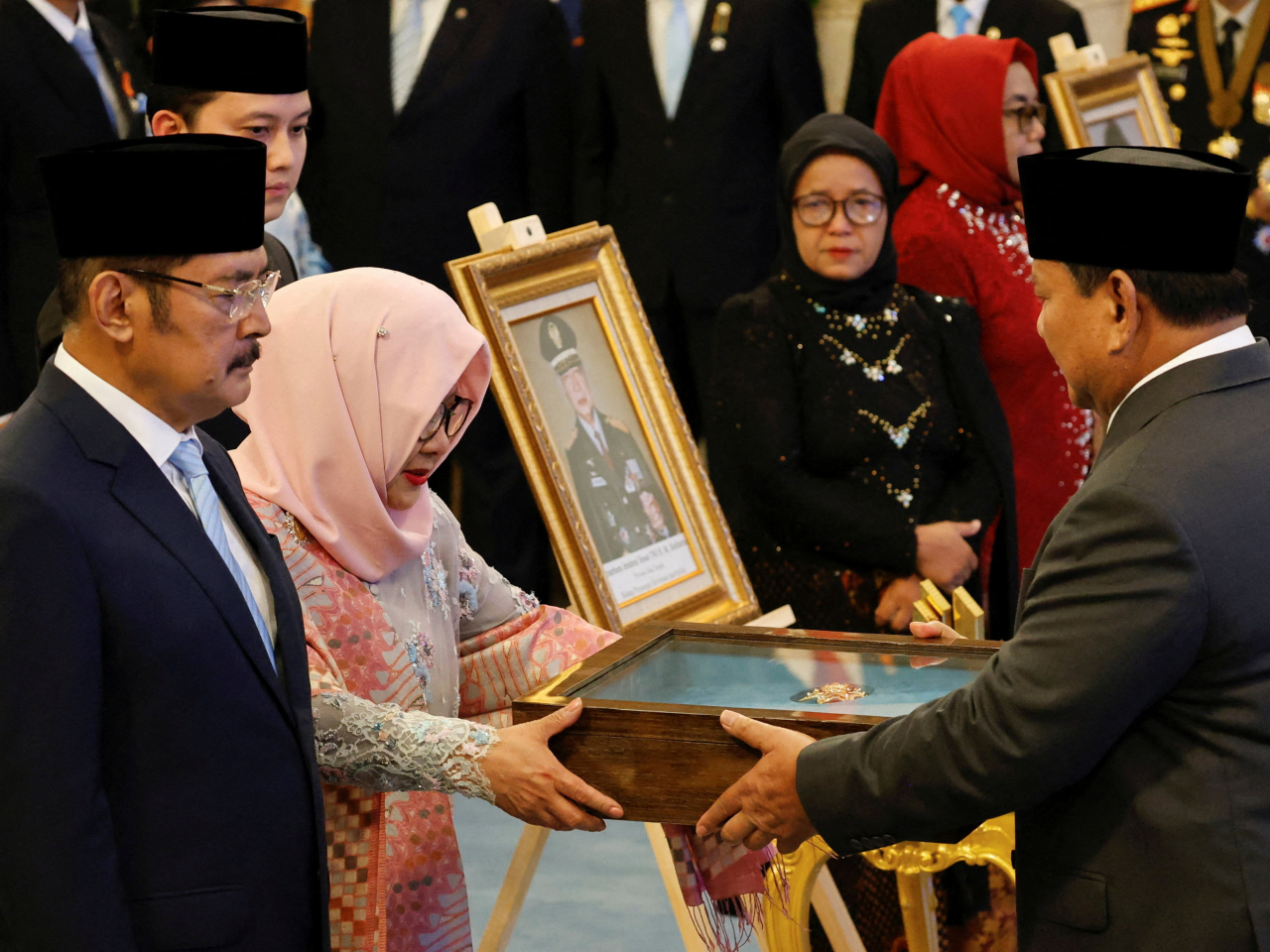 Prabowo Subianto presents a plaque to Siti Hardijanti Rukmana in honour of her father's designation. Photo: Reuters