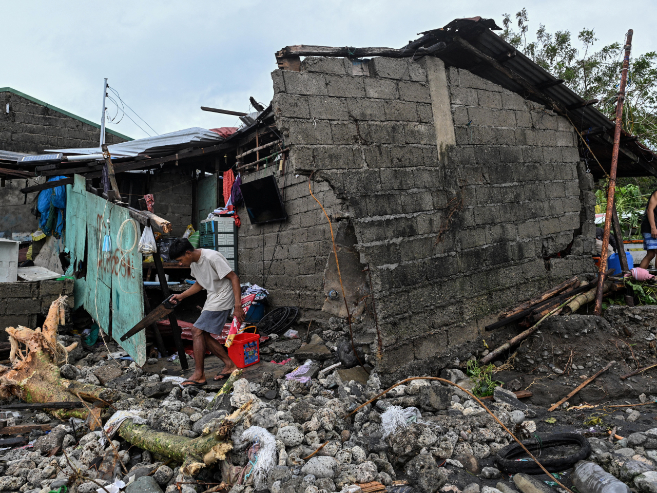 菲律賓有居民在颱風鳳凰過後，回家查看住所受損情況。（路透社）