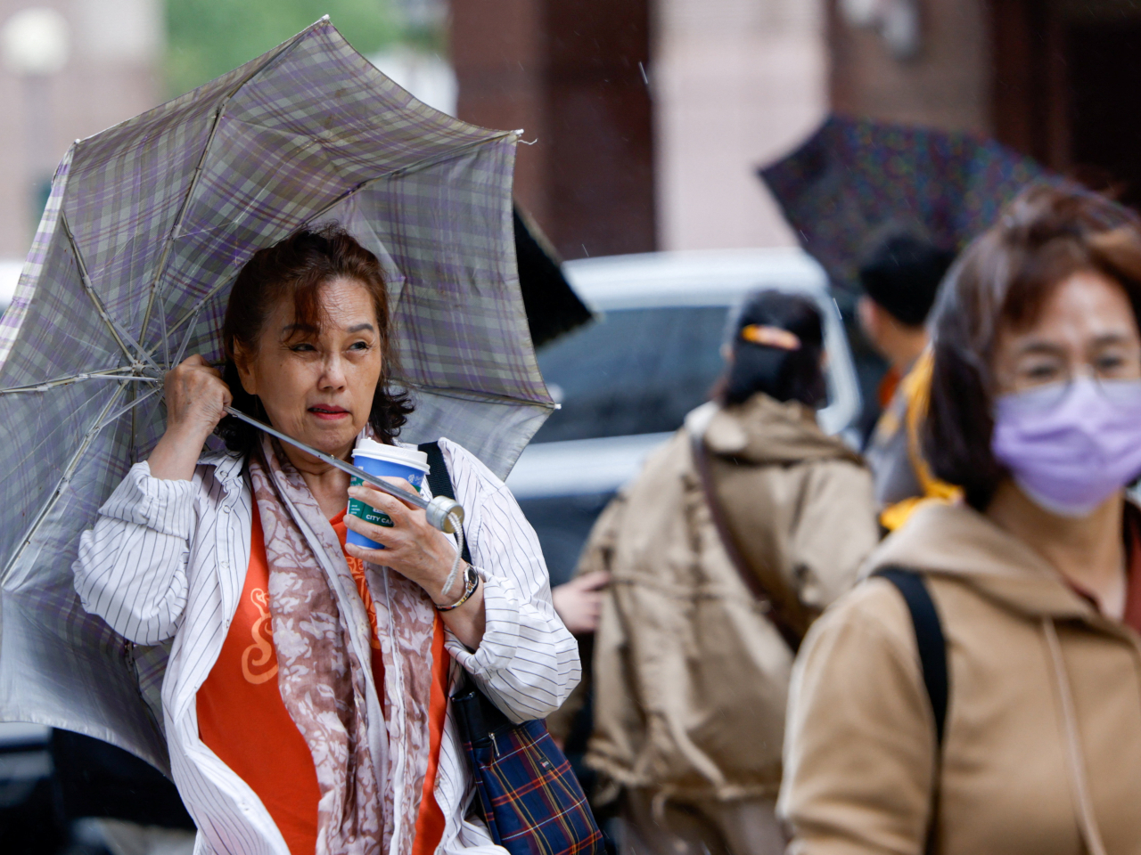 台北市風雨昨日增強，民眾外出時要擔起雨傘。（路透社資料圖片）