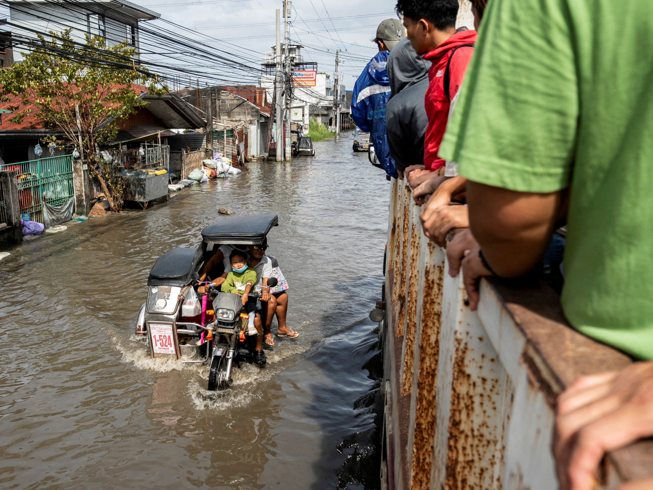 A ride aboard a truck in Macabebe, Pampanga, comes with views of the muddy waters that flood-control cons leave in the wake of typhoons such as Fung-wong. Photo: Reuters
