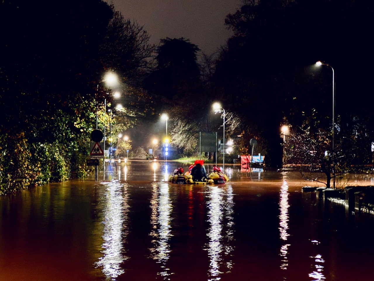 Rescue workers wade through floodwater in South Wales after a river burst its banks. Photo: South Wales Fire and Rescue Service via Reuters.