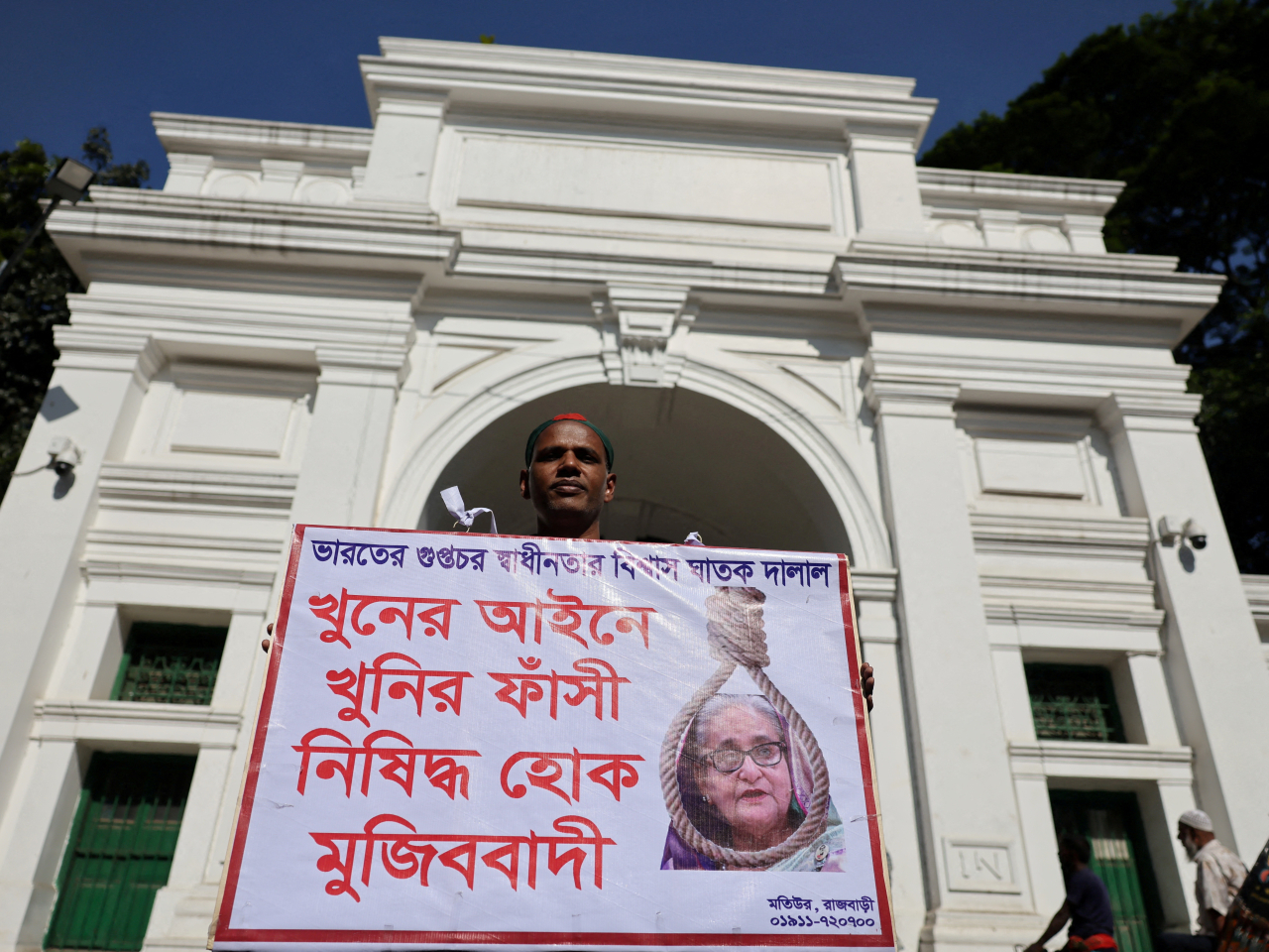 A man holds a poster demanding capital punishment for ousted Prime Minister Sheikh Hasina over her role in last year's crackdown that left hundreds dead. Photo: Reuters