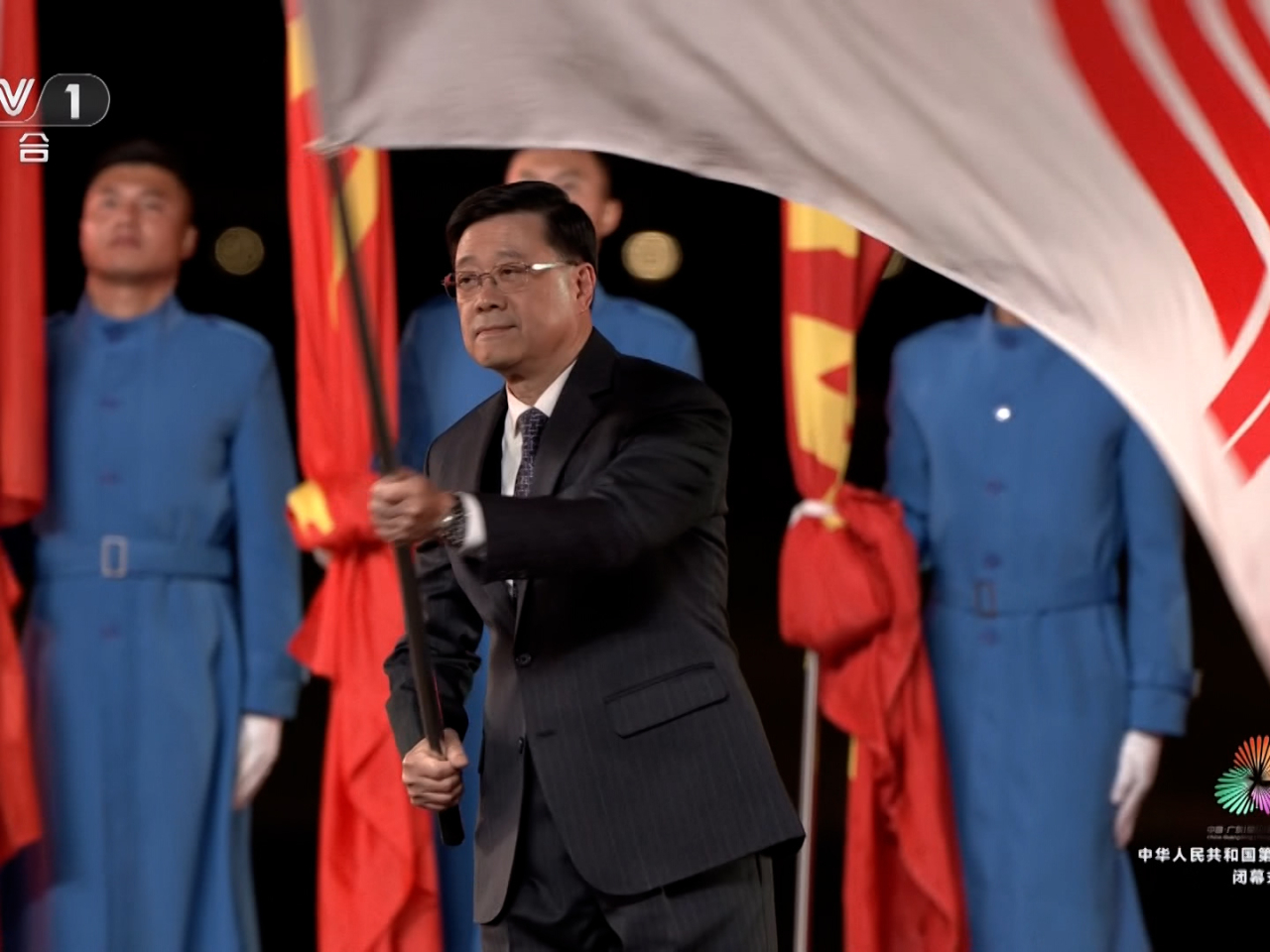 李家超聯同廣東省省長孟凡利和澳門特區行政長官岑浩輝一同將全運會會旗交接予下一屆全運會主辦方湖南省。（央視截圖）
