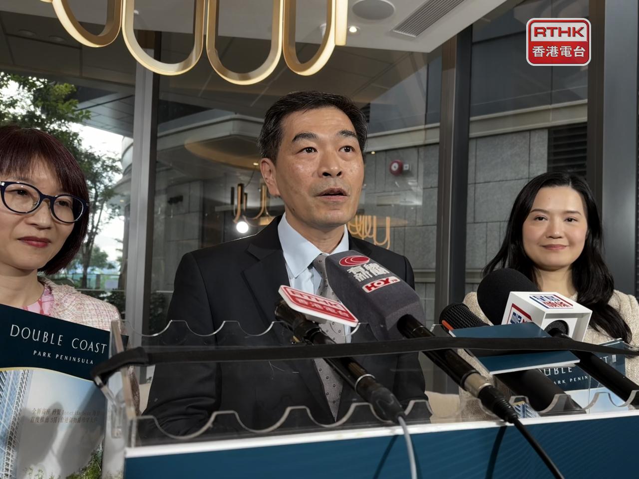 黃光耀（中）預計今年一手成交絕對有條件突破2萬宗，而荃灣地皮近日以高於市場預期價格投得，反映發展商信心有所回復。（趙嘉駿攝）