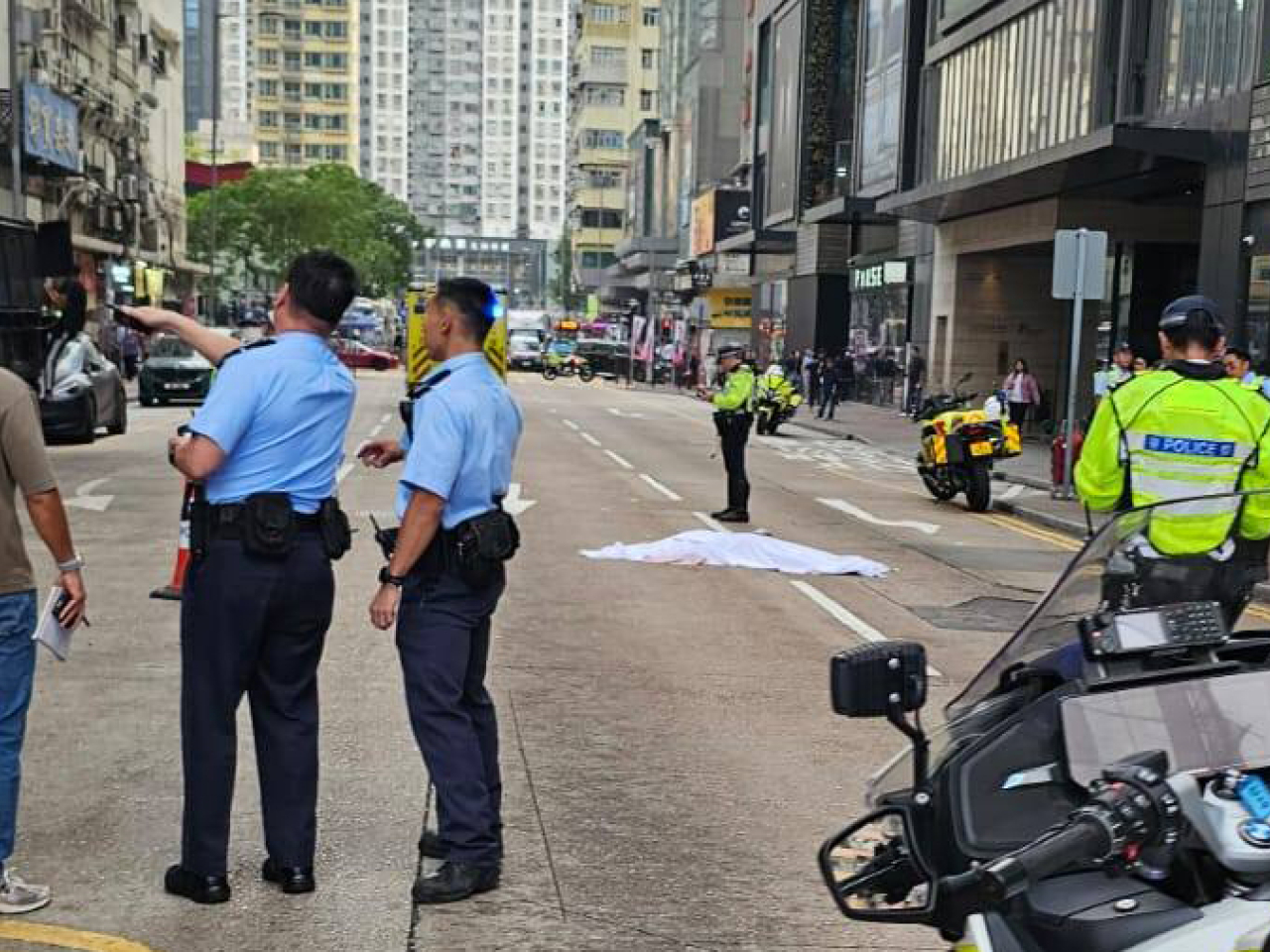 事發後現場遺下大批紙皮，警方用白布遮蓋死者遺體。（網上圖片）