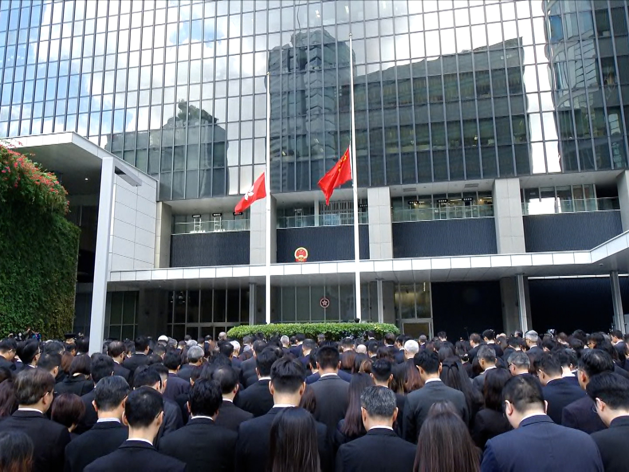 參加默哀的人士面向國旗及區旗肅立默哀。