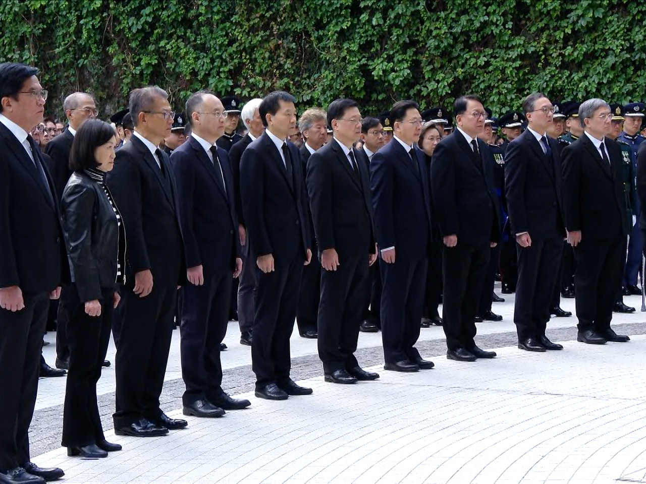 Chief Executive John Lee and officials observe three minutes of silence for the victims of the Wang Fuk Court fire in Tai Po. Photo: RTHK