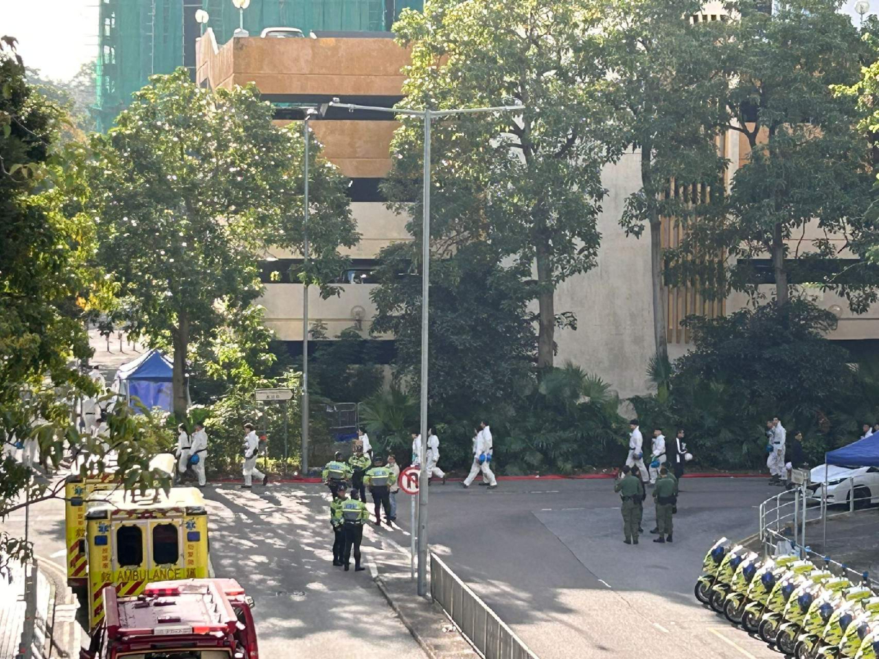 今早繼續有穿上白色衣服的人員到宏福苑現場工作。(林漢山攝)