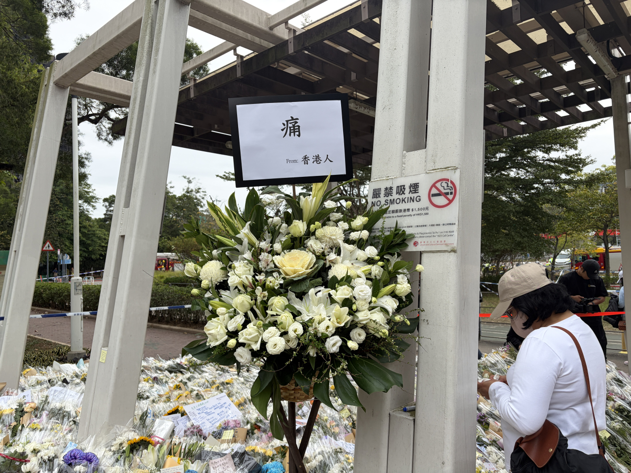People lay flowers at a park near Wang Fuk Court. Photo: RTHK