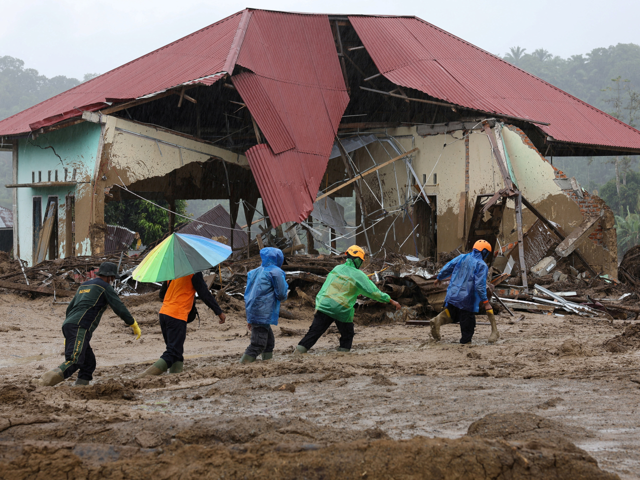 Rescuers trudge through Palembayan in West Sumatra, Indonesia. Photo: Reuters
