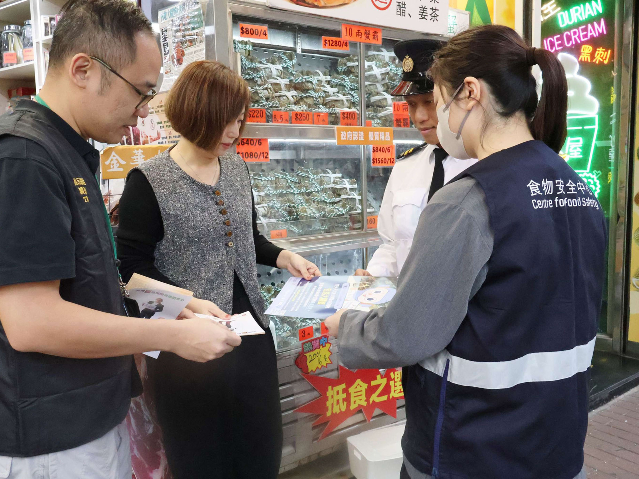 食環署和海關人員向相關處所負責人派發宣傳單張，提醒他們注意食物安全及遵從相關法例規定。（政府新聞處）
