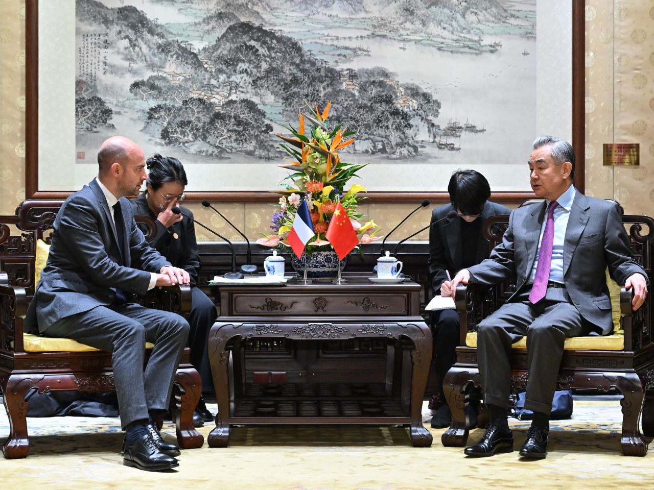 王毅（右）表示，面對當前錯綜複雜的全球挑戰，中法有必要加強溝通合作。（新華社）