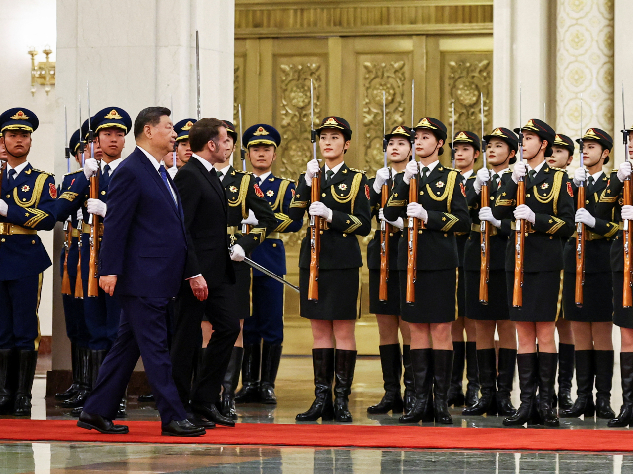 Xi Jinping and Emmanuel Macron inspect an honour guard out of the cold in the Great Hall of the People in Beijing. Photo: Reuters