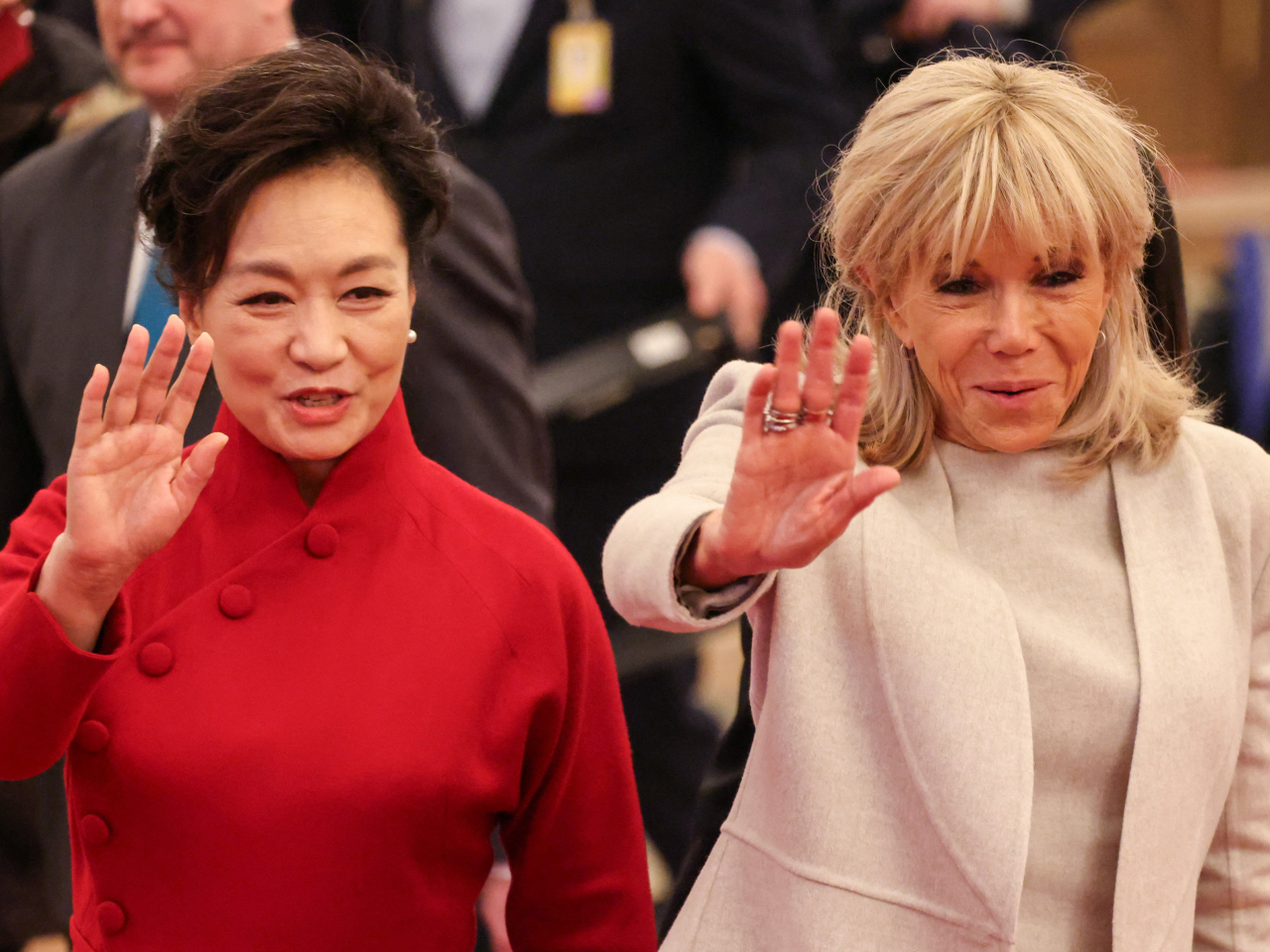 Peng Liyuan and Brigitte Macron wave to guests and well-wishers gathered in the Great Hall of the People. Photo: Reuters